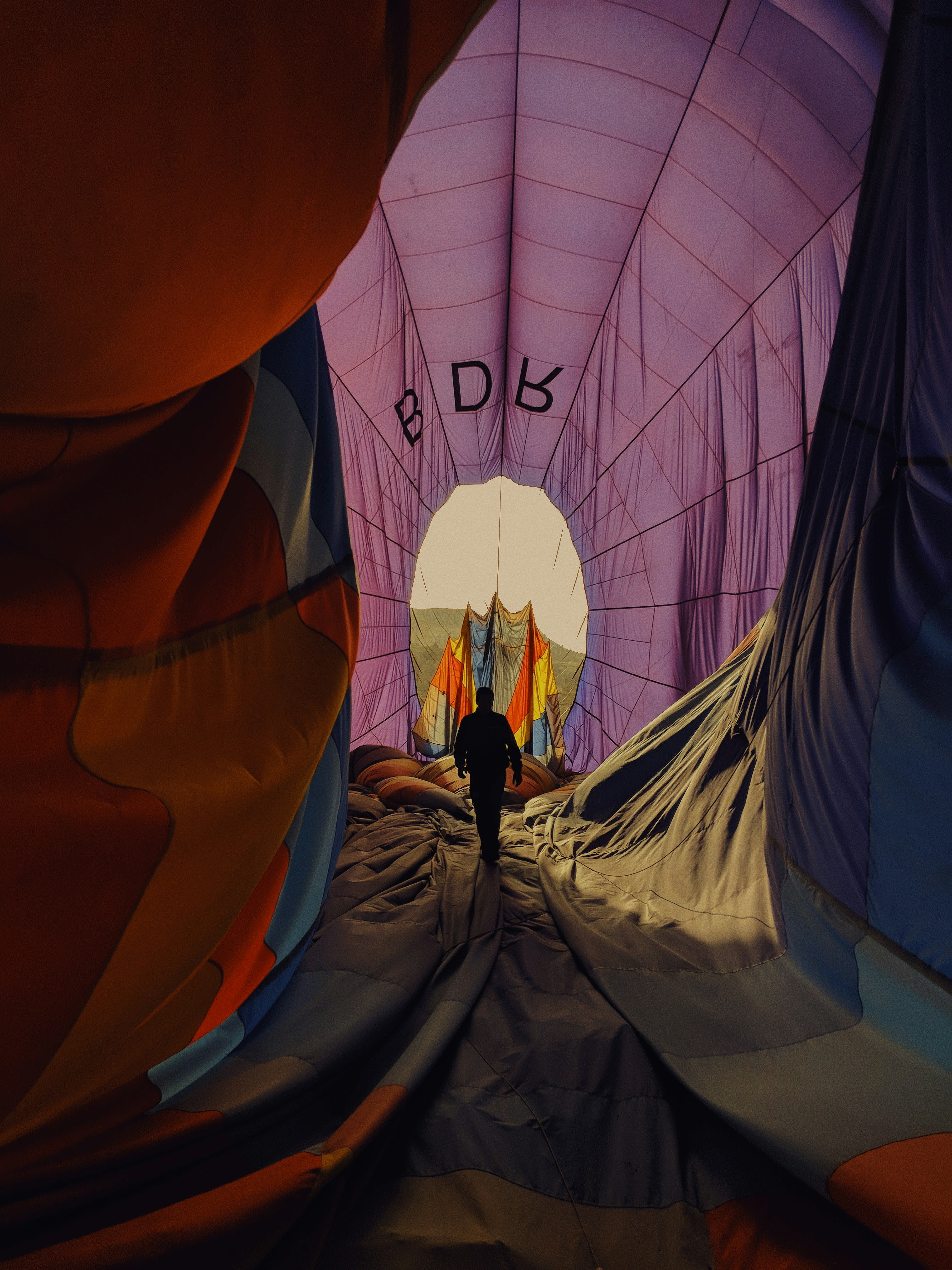 hot air balloon flying over the mountains during sunset